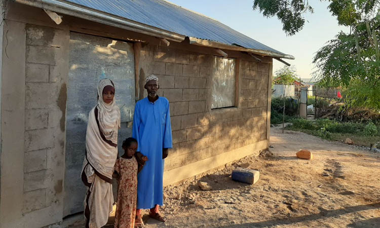 Abdi Bulle with his daughter infront of his house build by ANE